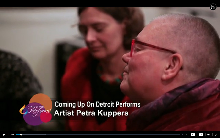 Detroit Performs screenshot with two white women (Petra and Stephanie), in red, eyes closed, meditative
